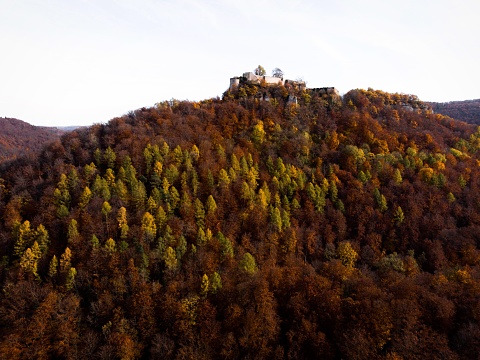 The ruins of Burg Hohenurach towering above colorful autumn forest near Bad Urach in Baden-Wuerttemberg, Germany