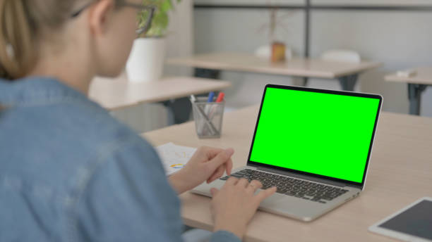 istock Young Woman Working on Laptop with Green Chroma Screen 1459195952
