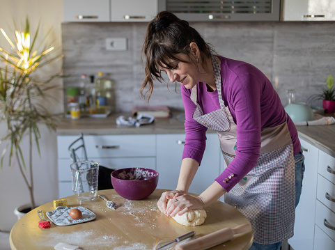 istock Young pretty woman is making a cookies in her kitchen. 1459197851