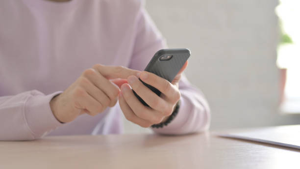 istock Close up of Male Hand Browsing Internet on Smartphone 1459199106