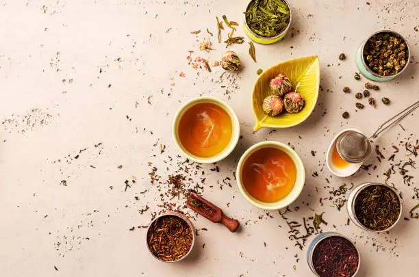 Photo of Various types of tea and hot brew in a cups from above (top view, flat lay). Chinese tearoom concept.