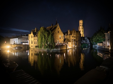 Classic postcard view of illuminated historical medieval buildings at Rozenhoedkaai Dijver river canal belfry belfort tower center Bruges West Flanders Flemish Region Belgium Europe