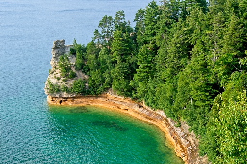 Pictured Rocks national Lakeshore provides stunning views of Lake Superior along this rocky coastline of the upper peninsula of Michigan. Colorful rock shoreline contrast with the green conifers.