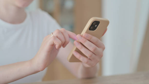 istock Close up of Female Hand Browsing Internet on Smartphone 1459200943