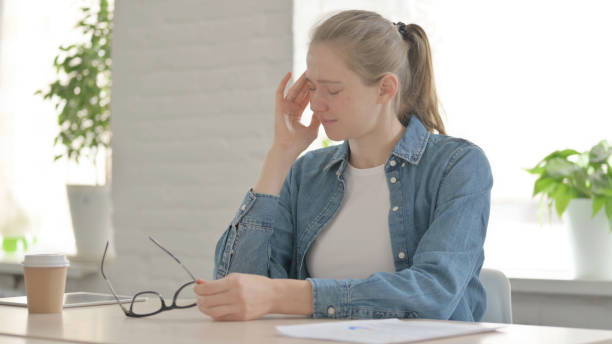 istock Young Woman having Headache while Sitting in Office 1459201291