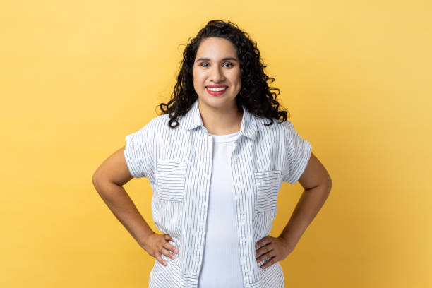 istock Woman standing with hands on hips, looking at camera with satisfied facial expression. 1459201348