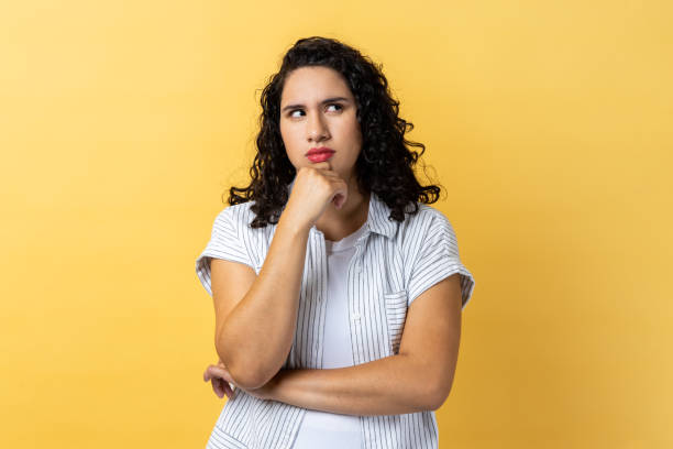 istock Woman holding chin and musing, looking away with thoughtful facial expression. 1459201363