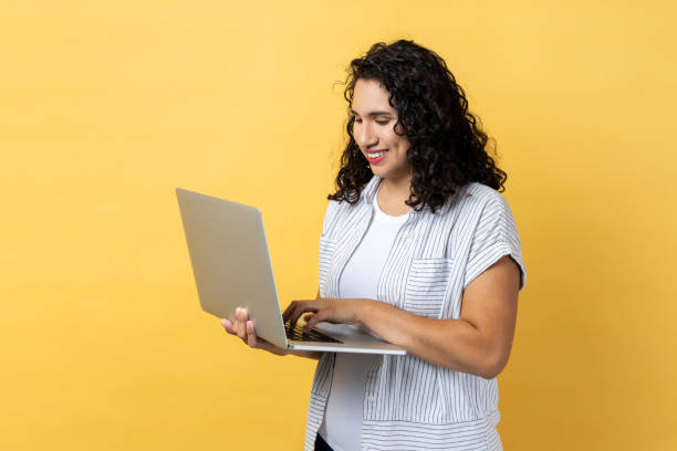 istock Woman working on laptop, looking at display screen with pleasant expression. 1459201375