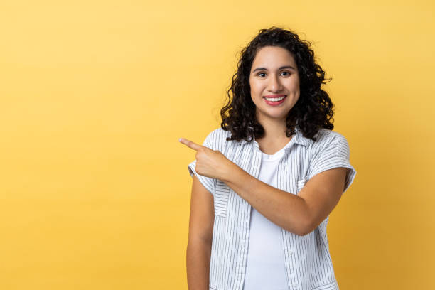 istock Woman standing pointing aside with finger, showing copy space for advertisement. 1459201377