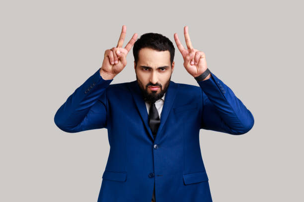 istock Crazy bearded man showing bull horn gesture with fingers over head, looking hostile and threatening. 1459202361