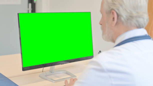 istock Senior Doctor Working on Desktop with Chroma Key Screen 1459203000