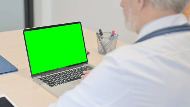 istock Senior Doctor Using Laptop with Green Screen 1459203022