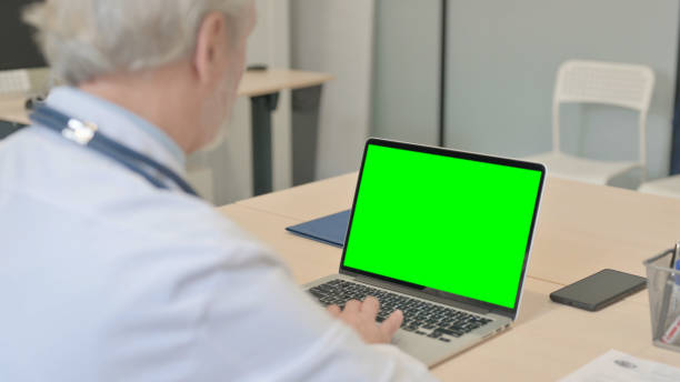 istock Senior Doctor Working on Laptop with Chroma Key Screen 1459203049