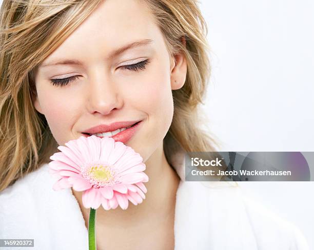 Primer Plano De Una Mujer Joven Oler Las Flores Foto de stock y más banco de imágenes de 20-24 años - 20-24 años, Adulto, Adulto joven