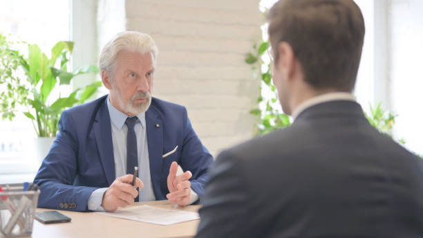 istock Senior Old Businessman Discussing Work with Businessman in Office 1459204577