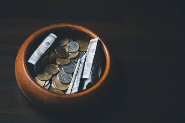 istock One tenth or tithe is basis on which Bible teaches us to give one tenth of first fruit to God. coins with Holy Bible. Biblical concept of Christian offering, generosity, and giving tithes in church. 1459204950