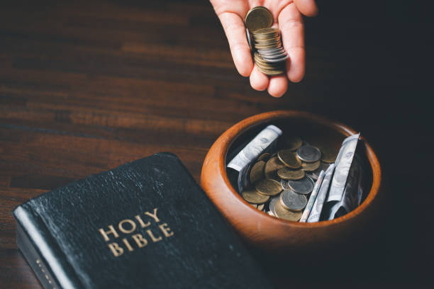 istock One tenth or tithe is basis on which Bible teaches us to give one tenth of first fruit to God. coins with Holy Bible. Biblical concept of Christian offering, generosity, and giving tithes in church. 1459205093