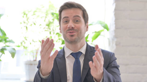 istock Online Video Chat by Talking Young Businessman in Office 1459205329
