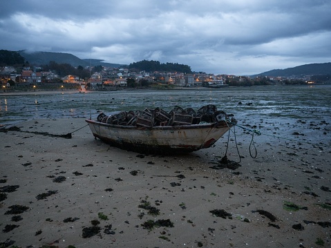 Stranded fishing boat vessle ship on shore of seaside traditional historical old fishing town village Combarro Poyo Pontevedra Poio Galicia Spain Europe at low tide