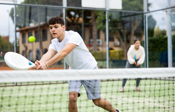 istock Guy hitting two handed backhand during paddle tennis match 1459206806