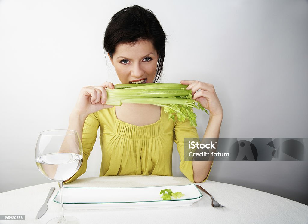 young woman having her breakfast with water and celery Adult Stock Photo