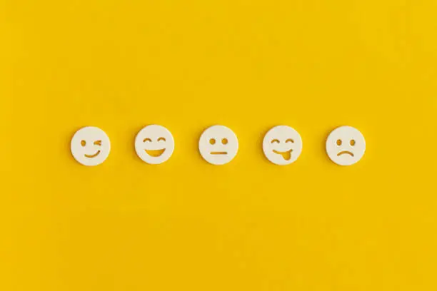Photo of Emoticon smile on a yellow background. Customer feedback.
