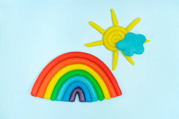 istock Plasticine rainbow, cloud, sun with rays on blue background. Plasticine creativity, children's hobby concept 1459215082