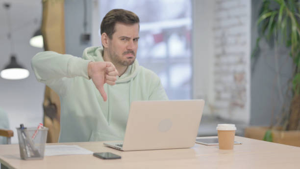 istock Thumbs Down by Young Man Working on Laptop 1459215962
