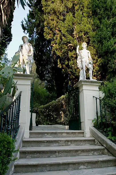 Stairs to garden at Achillion palace with two statues