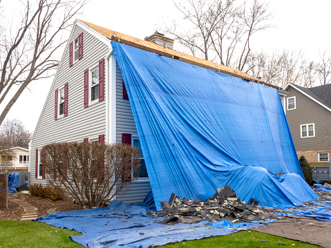 Pile of shingles laying on tarp during a roof replacement