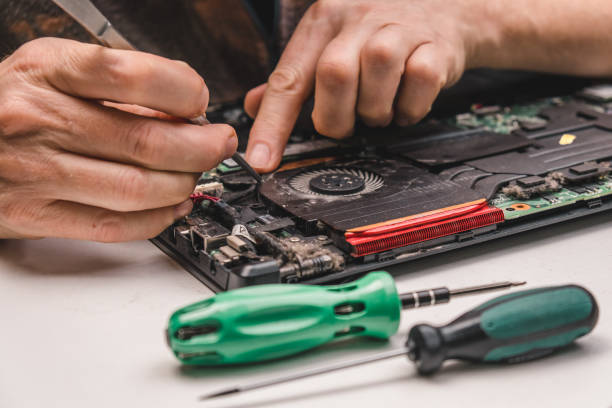 istock computer repair technician removes laptop's cooling system from case for cleaning and maintenance. close up. 1459224883