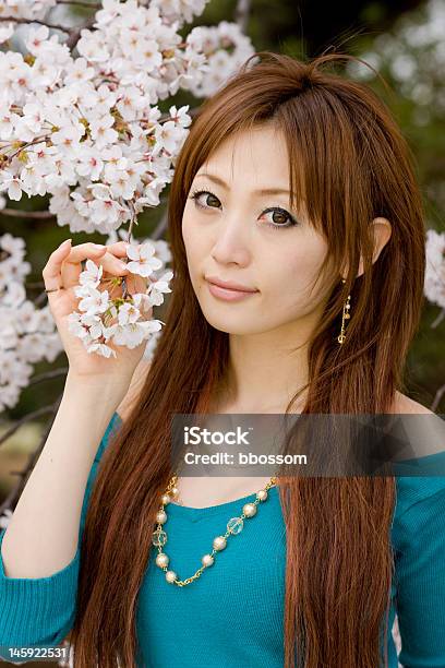 Foto de Mulher Com Flores De Cereja Japonesa e mais fotos de stock de Adulto - Adulto, Azul, Beleza