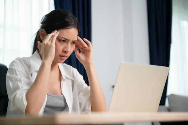 istock Office syndrome. Overworked tired young asian woman feeling headache, having eyesight problem after computer laptop work. Stressed young woman suffering from fatigue at home 1459227303