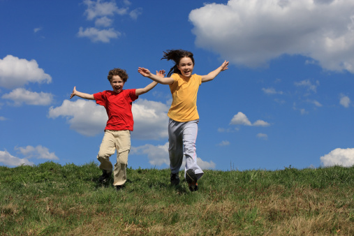 Kids running on green meadow
