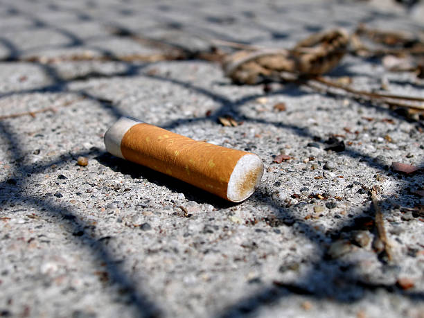 istock close up shot of cigarette butt on pavement 145923550
