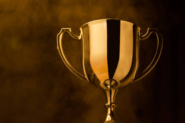 gold trophy competition in the dark with smoke and with copy space - gold medal medal winning trophy imagens e fotografias de stock