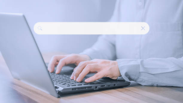 istock Businessman's hand working with computer laptop on desk in home. Searching Browsing Internet Data Information with blank search bar. Search Engine Optimization SEO Networking Concept. 1459240503