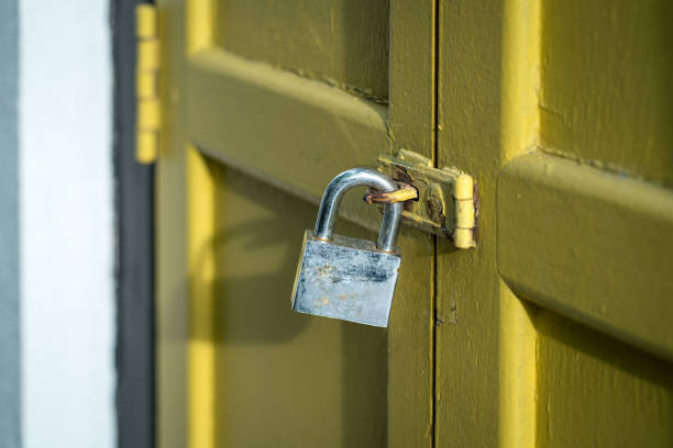 istock Yellow wood door closed with rusty padlock. 1459241744