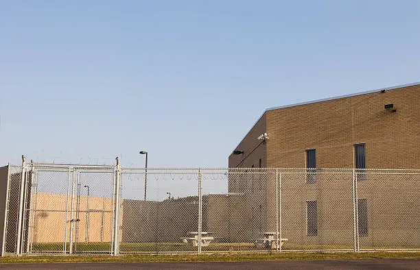 Prison / Jail yard surrounded by two layers of fence and barbed wire