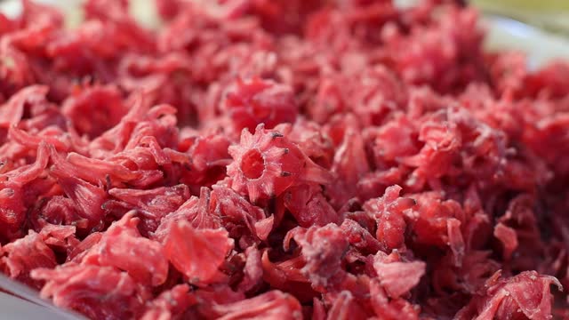 Dried red hibiscus fruit on the counter of the store.