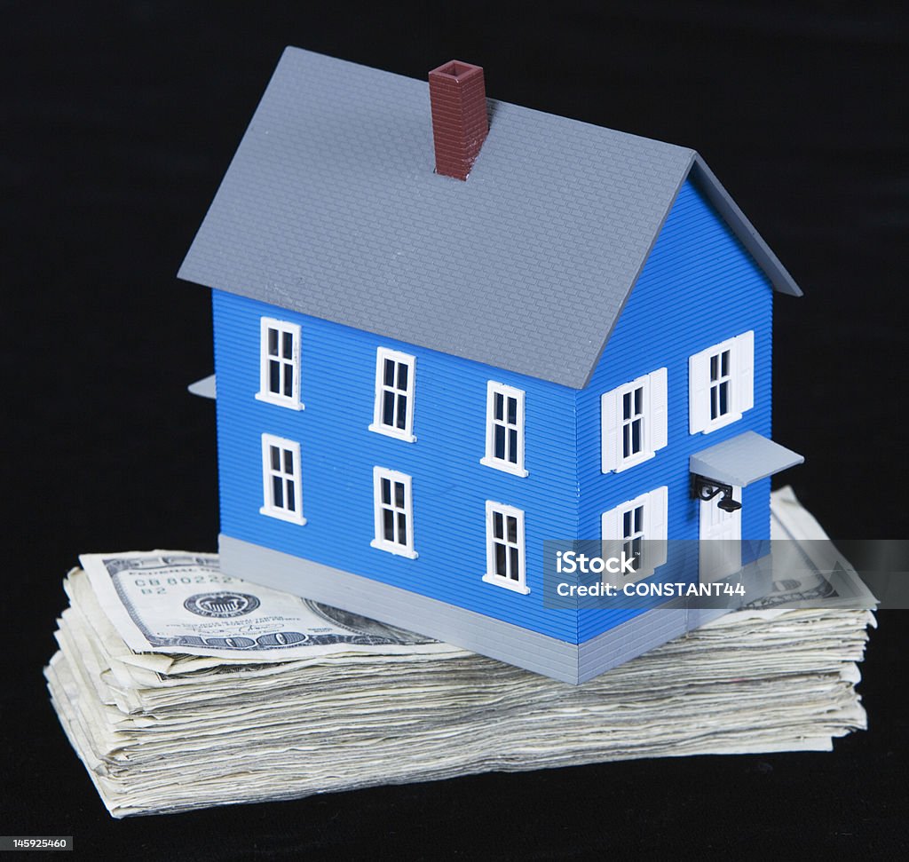 miniature house sitting on top of hundred dollar bills miniature house balancing on top of a stack of one hundred dollar bills on black background American One Hundred Dollar Bill Stock Photo
