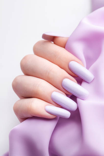 istock Girl's hands with a soft purple manicure. 1459256808