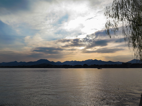 A calm seascape with mountains at sunset. Dramatic sky and cloudscape. For travel, background and blog etc. concepts.