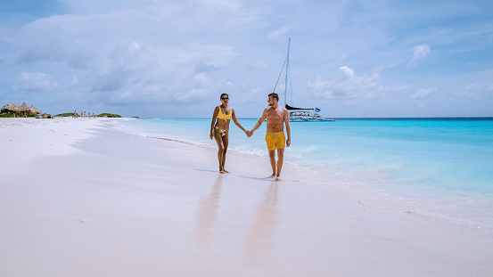 Small Curacao Island famous for day trips and snorkeling tours on white beaches and blue clear ocean, Curacao Island in the Caribbean sea. a couple of men and woman on the beach during a vacation
