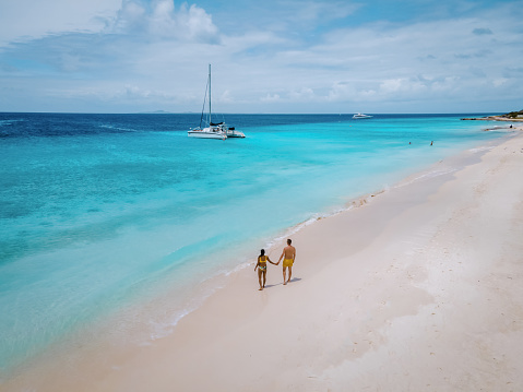 Small Curacao Island famous for day trips and snorkeling tours on white beaches and blue clear ocean, Curacao Island in the Caribbean sea. a couple of men and woman on the beach during a vacation