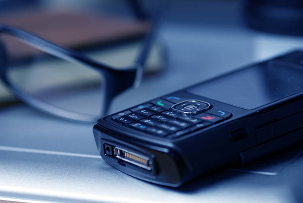 Closeup picture of a keyboard with a phone lying above it,selective focus