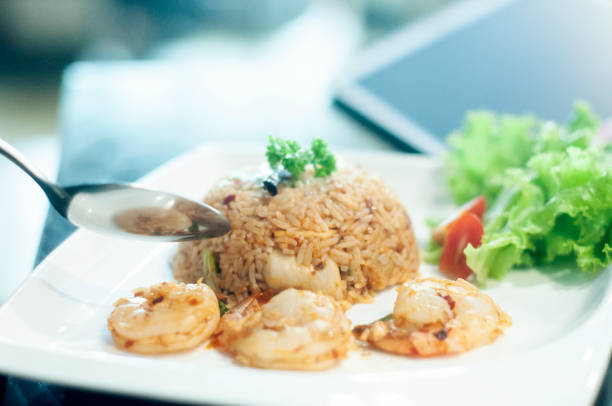 Thai Shrimps chilli paste fried rice garlic with green leaves watercress tomato  side dish famouse menu of Asian gourmet cuisine chef's choice of selection with silver spoon