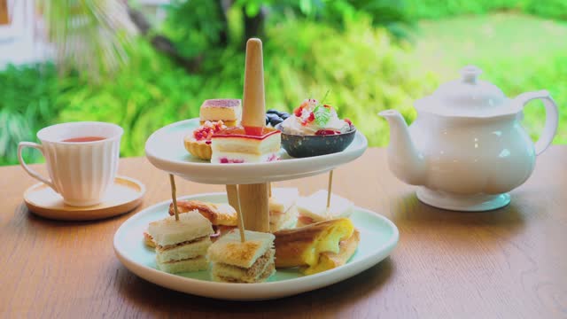 Afternoon tea stand with assortment of sweets, cakes, sandwiches