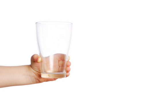 Little child holding empty transparent glass