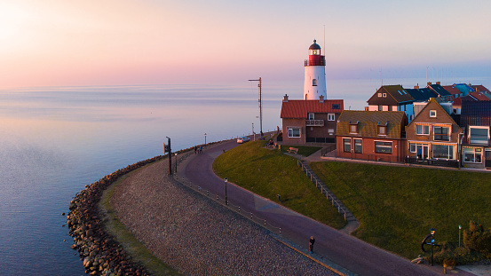 Drone view at Urk Flevoland Netherlands sunset at the lighthouse and harbor of Urk Holland. Fishing village Urk. Beautiful sunset during the evening